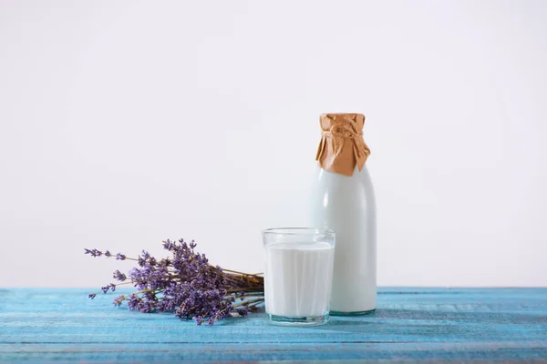 Bottiglia e bicchiere di latte con lavanda — Foto Stock