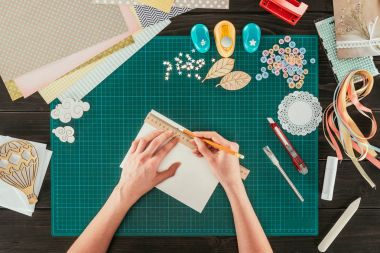 cropped image of woman measuring paper for scrapbooking postcard clipart