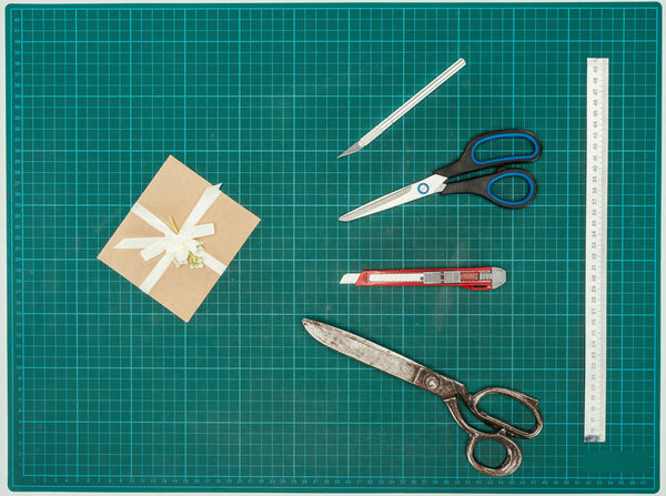 Вид сверху ручной работы с ножницами и ножами на бирюзовой поверхности
