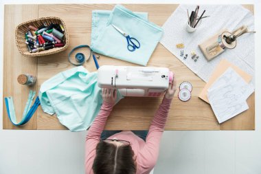 top view of woman seamstress at workplace with sewing machine clipart