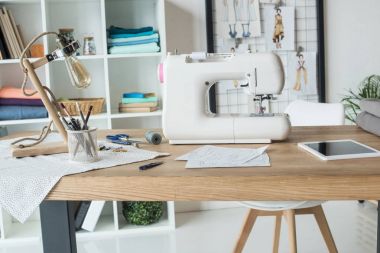 seamstress workplace with sewing machine on table clipart