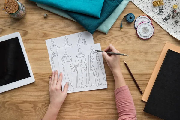 女性の裁縫師の職場で下書きを描く女性のトリミングの手の上から見る — ストック写真