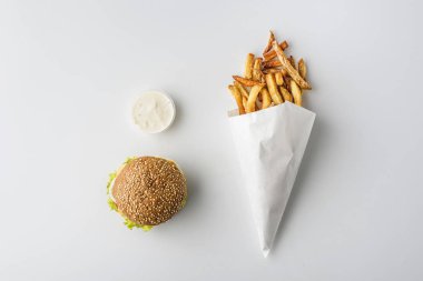 Fransız kızartması kağıt koni, hamburger ve mayonez, üzerinde beyaz izole Üstten Görünüm