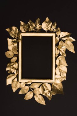 top view of golden photo frame and leaves isolated on black clipart