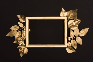 top view of golden photo frame and leaves isolated on black clipart