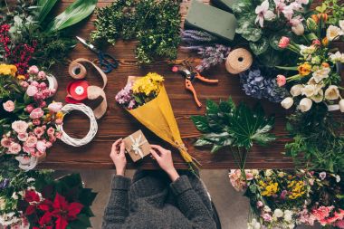 cropped image of florist holding postcard to add to bouquet clipart