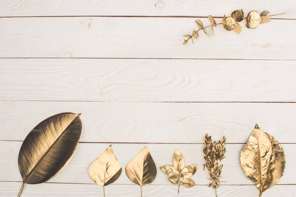 top view of set of different golden leaves on wooden tabletop