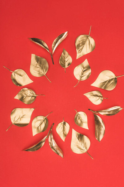 top view of arranged in circle golden leaves isolated on red