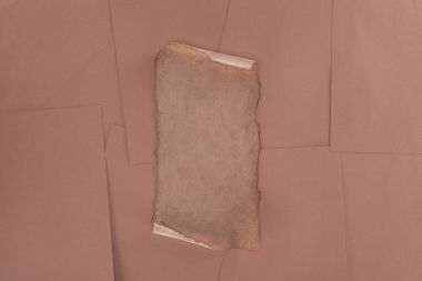 top view of old damaged paper over brown paper background clipart