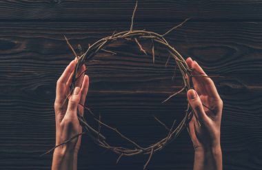 cropped image of woman holding crown of thorns in hands  clipart