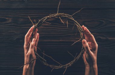 cropped image of woman holding crown of thorns in hands  clipart