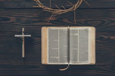 top view of crown of thorns with cross and bible on table clipart