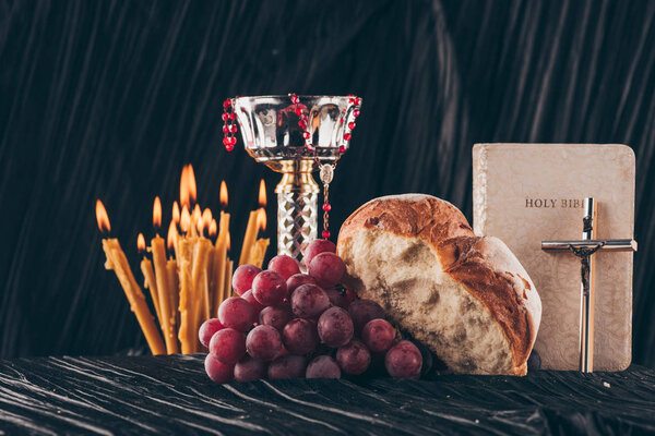 chalice, holy bible, christian cross, candles and food for Holy Communion