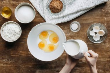 yumurta ve süt pasta için karıştırma kadın görüntüsünü kırpılmış