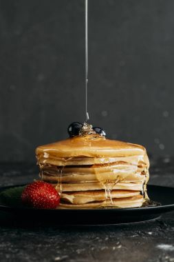 close-up shot of maple syrup pouring onto stacked pancakes clipart