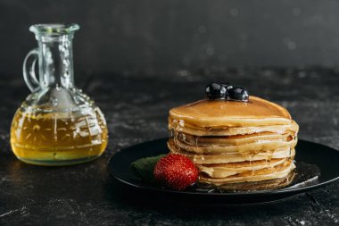 stack of freshly baked pancakes poured with maple syrup clipart