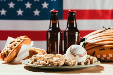 close-up view of baseball ball on plate with peanuts and beer bottles clipart