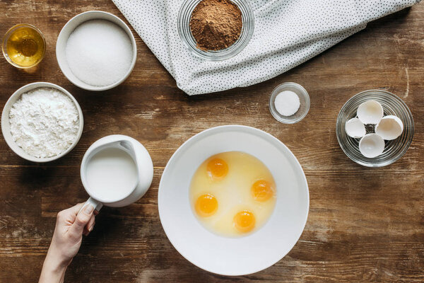 top view of woman mixing ingredients for pastry in bowl