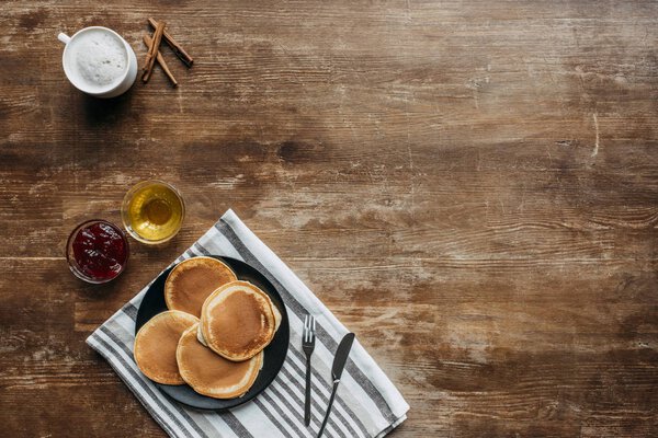 top view of pancakes on striped napking and coffee cup on wooden table