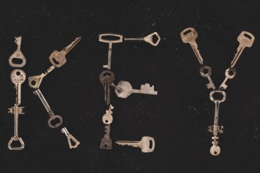 top view of metal keys forming word on black table clipart