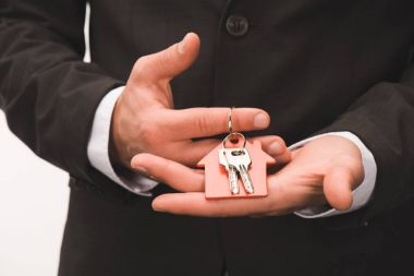 beyaz izole evinden anahtarı tutan adamın kırpılmış görüntü