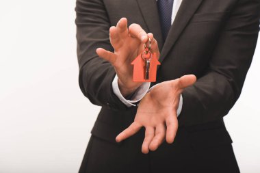 beyaz izole evinden anahtarı tutan adamın kırpılmış görüntü