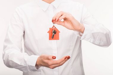 cropped image of female holding key from house isolated on white clipart