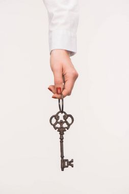 cropped image of female hand holding vintage key isolated on white clipart