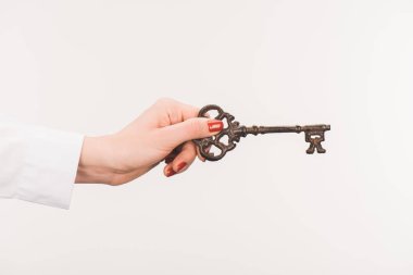 cropped image of female hand holding vintage key isolated on white clipart