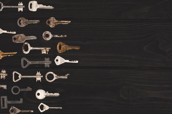 top view of different vintage keys on black table