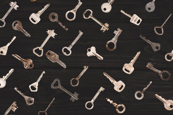 top view of different metal keys on black table