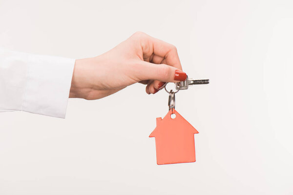 обрезанное изображение женской руки с ключом от дома, изолированным на белом
