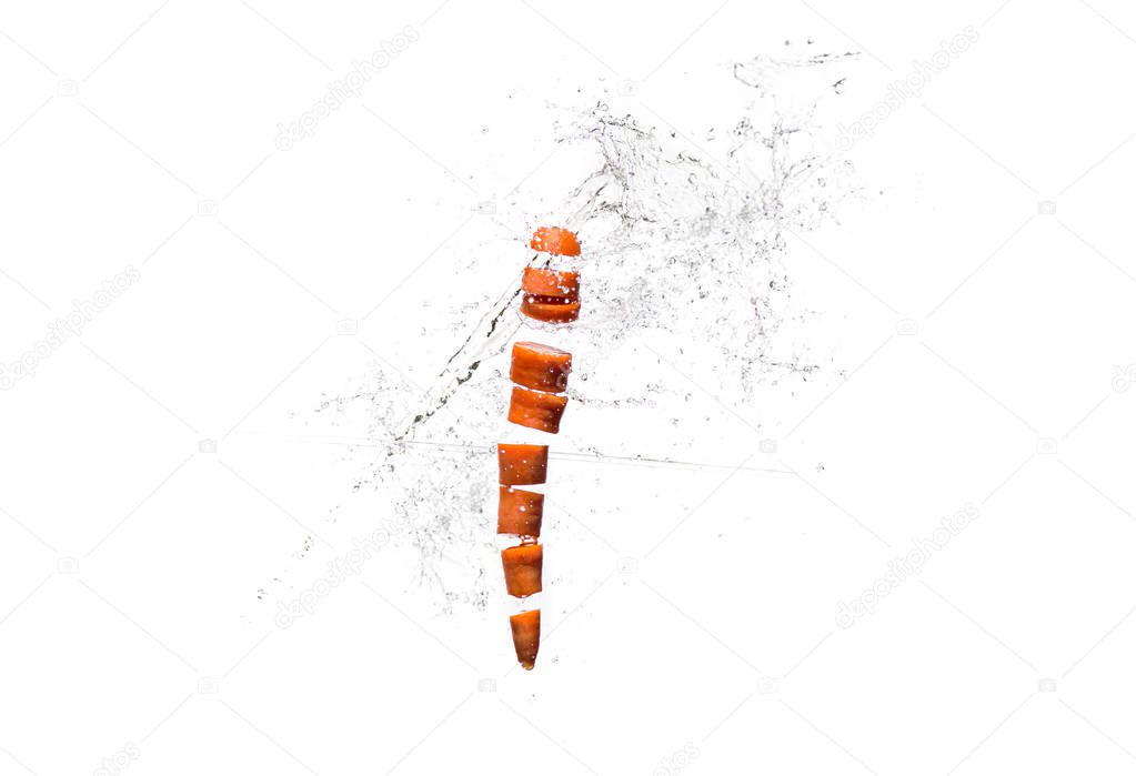 Fresh sliced carrot in water splashes isolated on white