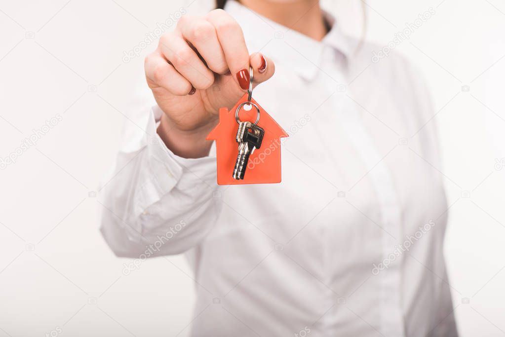 cropped image of female holding key from house isolated on white