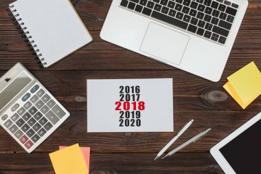 ahşap yüzey üzerinde dijital cihazlar, ofis malzemeleri ve 2018 takvim Üstten Görünüm