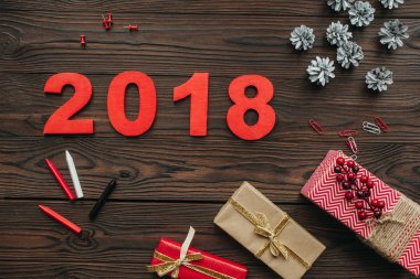 düz lay Noel hediyeleri, çam kozalakları ve koyu ahşap masa 2018 yıl işareti ile
