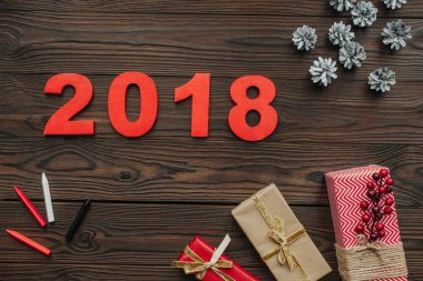 düz lay Noel hediyeleri, çam kozalakları ve koyu ahşap masa 2018 yıl işareti ile