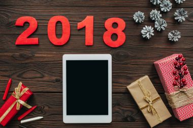 tablet, sarılmış hediyeler ile 2018 numaraları ahşap yüzey üzerinde düz lay