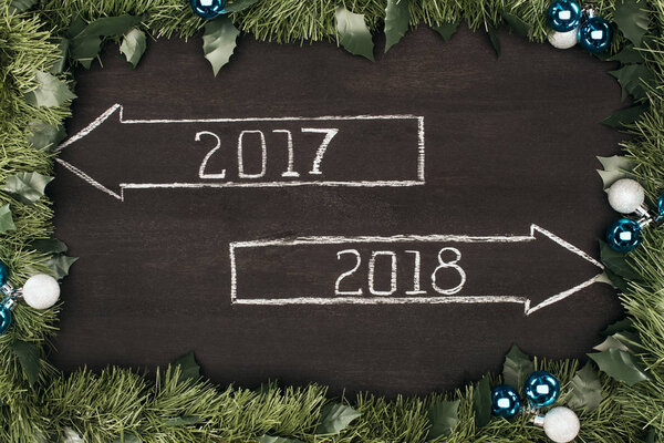 top view of 2017, 2018 year signs with christmas decorations around on dark wooden surface