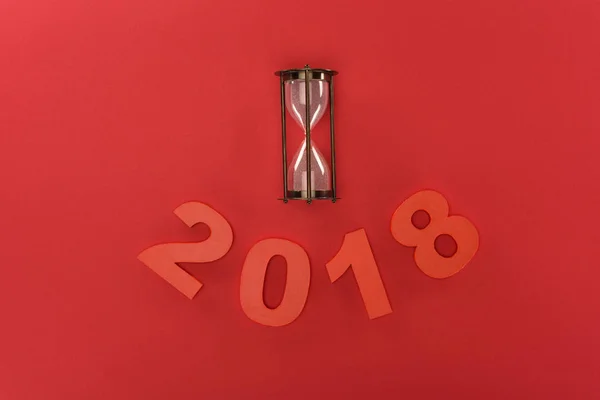 顶部视图2018年年标志和沙子时钟隔绝在红色 — 图库照片