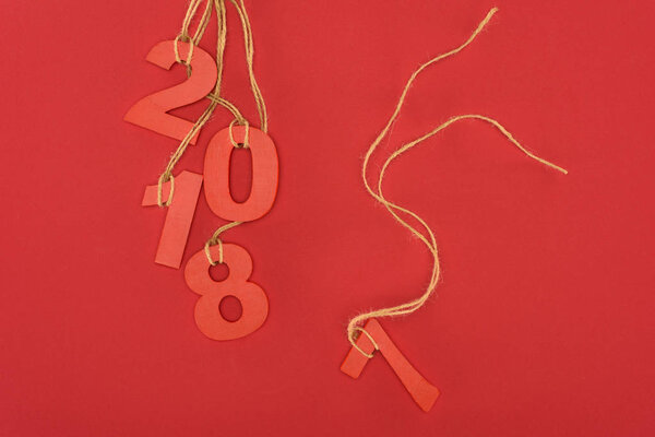 close up view of 2018 year sign hanging on strings isolated on red