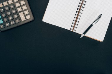 boş açık defter kalem ve hesap makinesi ile üstten görünüm siyah
