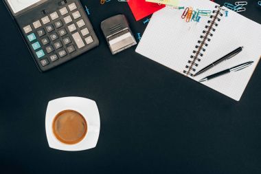 fincan kahve, hesap makinesi ve ofis malzemeleri üstten görünüm siyah