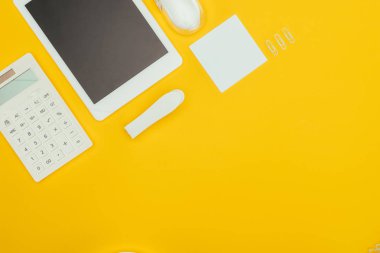 Sarı izole boş ekran, hesap makinesi ve ofis malzemeleri ile dijital tablet Üstten Görünüm