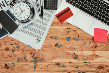 tablo üzerinde gazete, dizüstü bilgisayar, kredi kartı, akıllı telefon ve office üstten görünüm sağlar