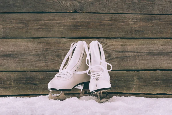 Par Patins Brancos Neve Perto Parede Madeira — Fotografia de Stock