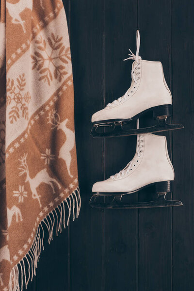 pair of white skates and scarf hanging on wall