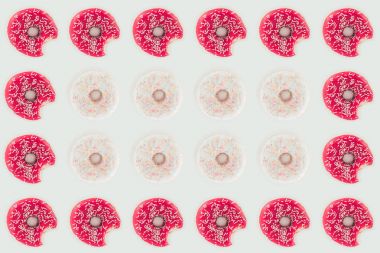 top view of seamless pattern of bitten pink and white doughnuts isolated on white clipart