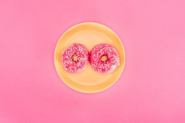 pembe sırlı çörek üstten görünüm pink izole sarı plaka üzerinde