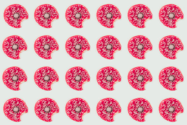 top view of bitten pink doughnuts seamless pattern isolated on white